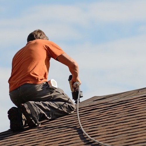A Roofer Works on Roof Leak Repair.