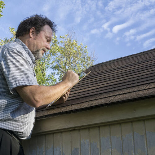 A Roofer Performs a Roof Inspection.