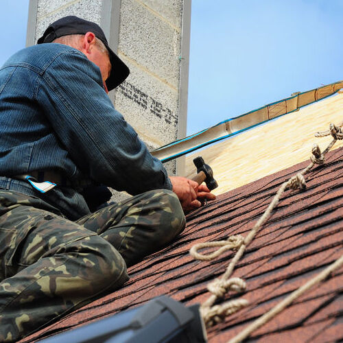 A Roofer Repairs Shingles