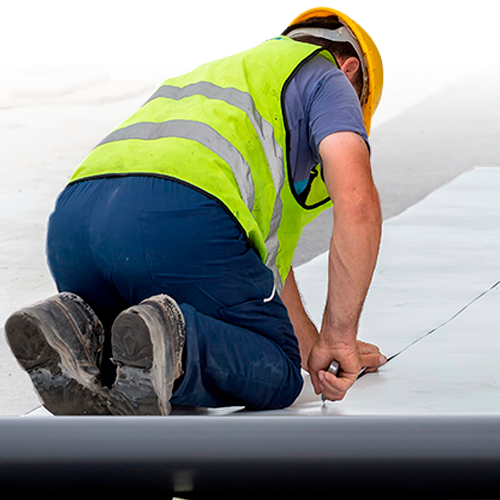 A Roofer  Prepares Roofing Material.